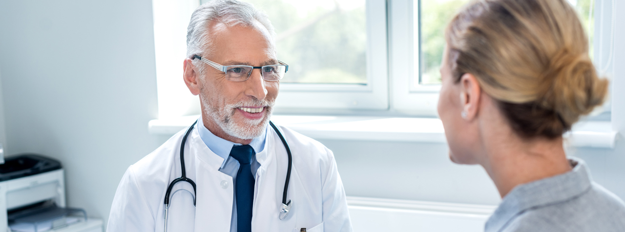 doctor in his office smiling at a patient